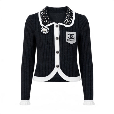 Black ribbed Chanel cardigan with pearl-studded collar, camellia brooch and white trim