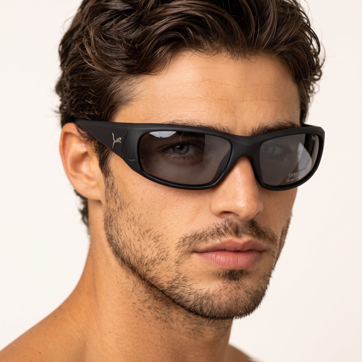 Close-up of man wearing matte black Puma sport sunglasses with polarised lenses
