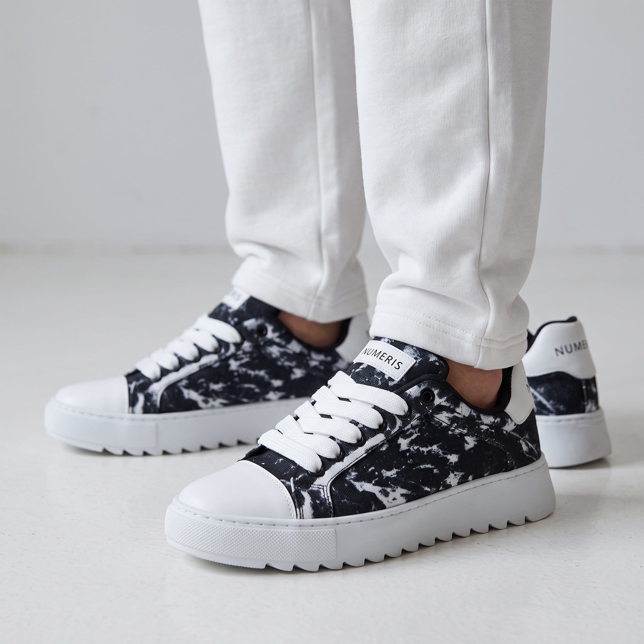 Numeris black and white marble low-top sneakers with chunky white platform sole