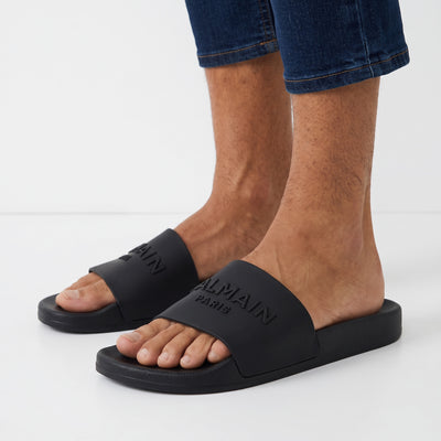 Black Balmain logo slide sandals on model feet