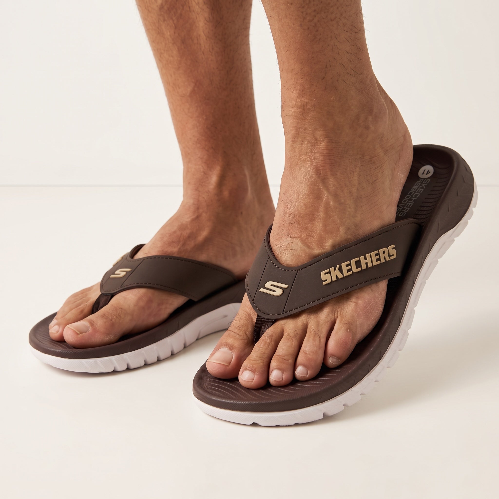 brown Skechers flip-flop sandals with white sole and Skechers logo on strap