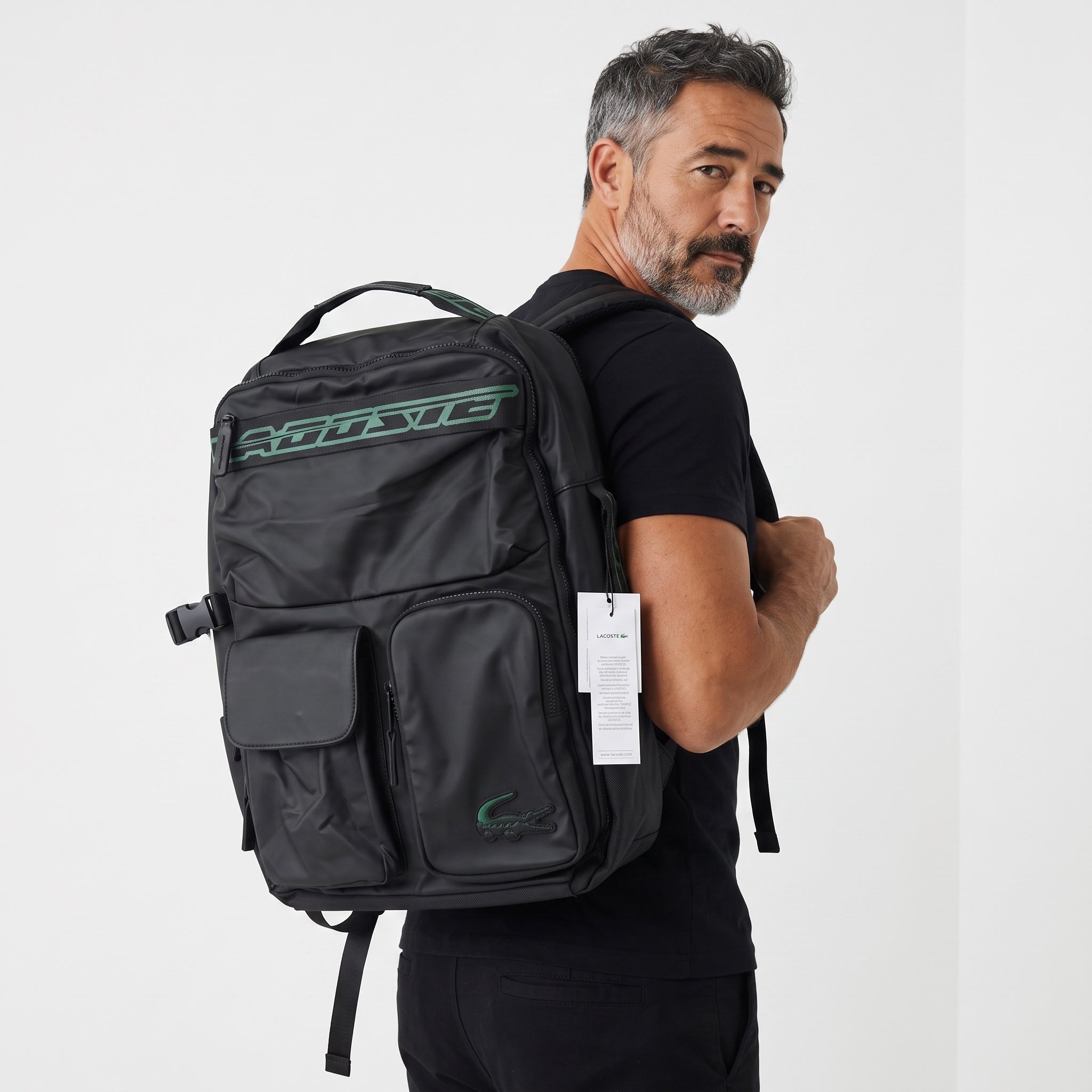 Black Lacoste backpack with green logo patches and multiple exterior pockets