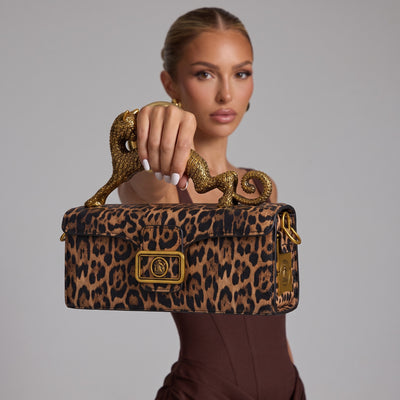 Leopard print satchel with ornate gold panther top handle and gold buckle hardware