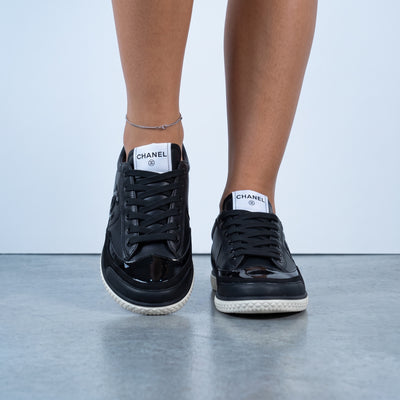 Chanel black low-top sneakers with white textured sole and CC logo