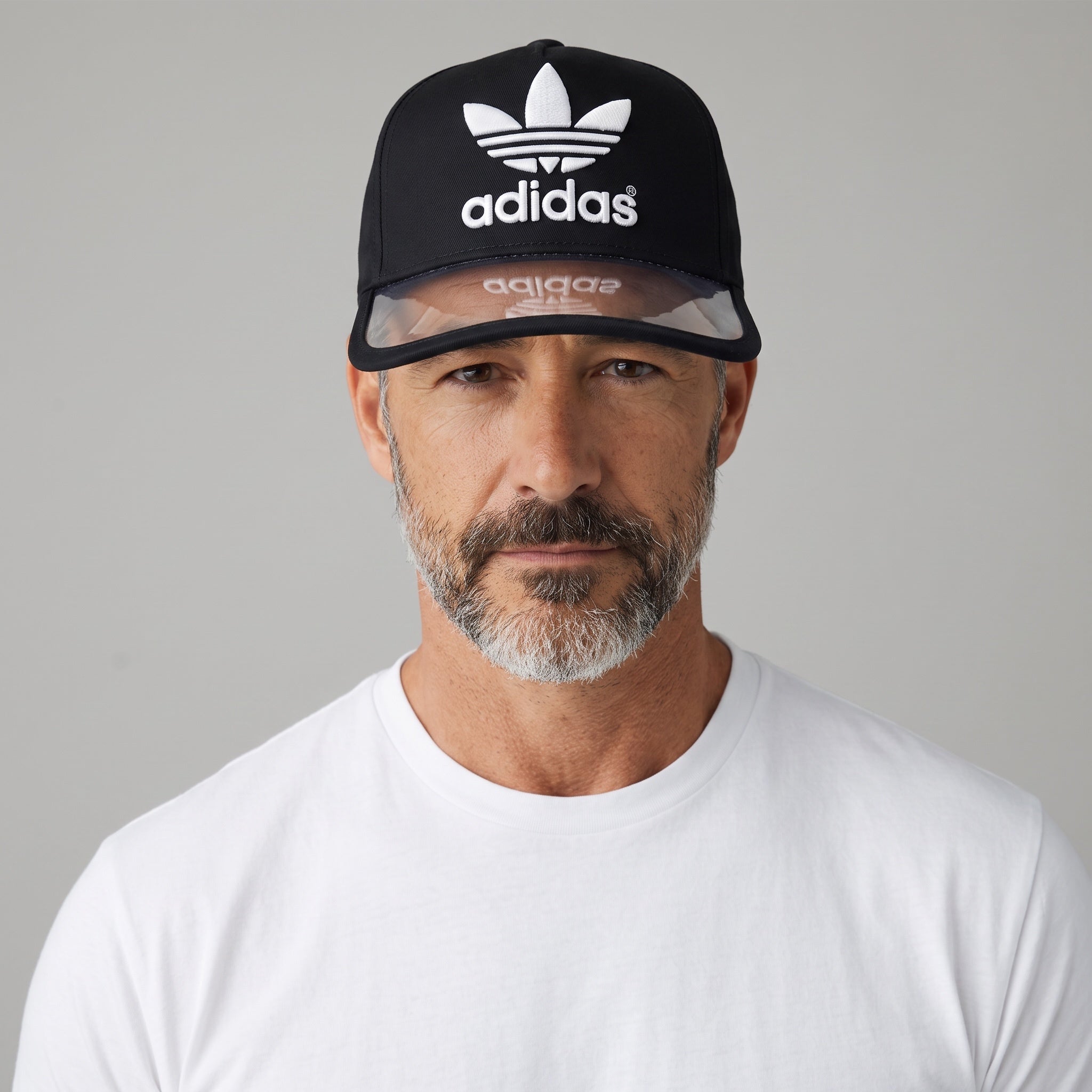 Man wearing a black Adidas Trefoil cap with a clear brim