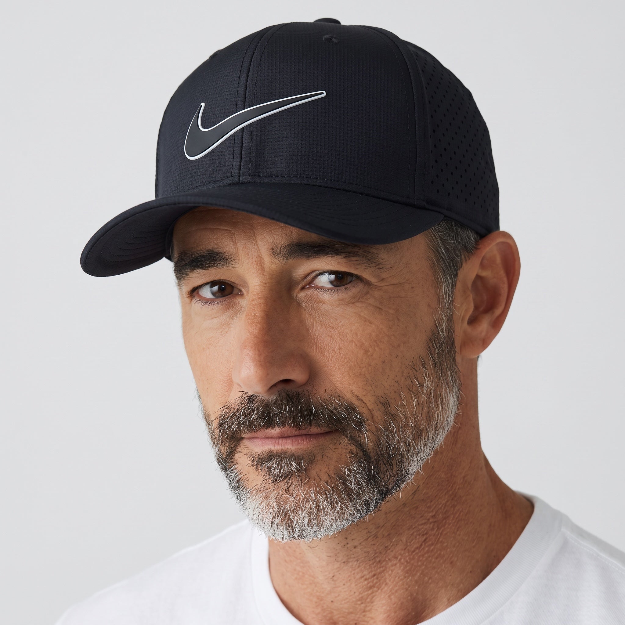 Man wearing a black Nike perforated sport cap with rubberized Swoosh logo