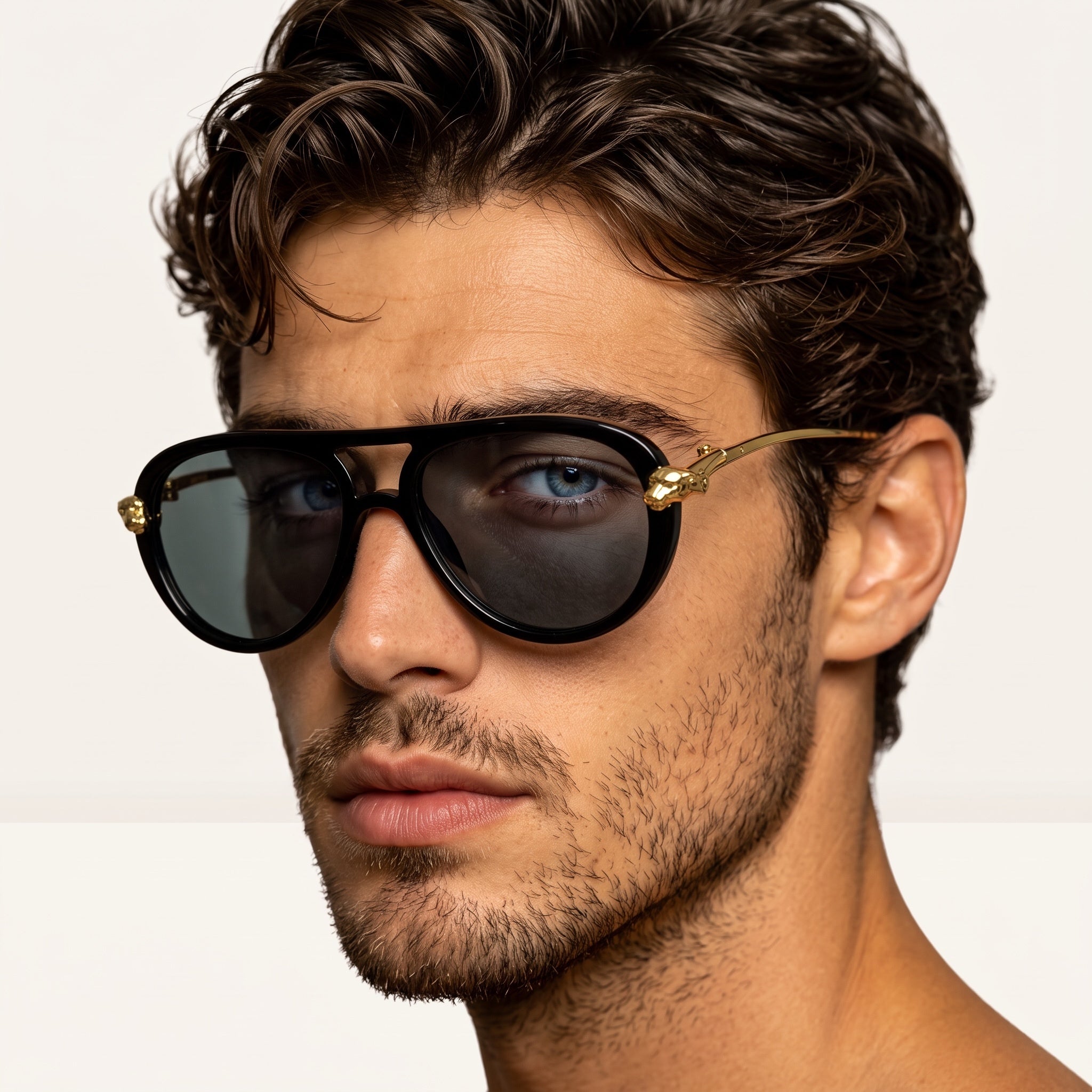 Close-up of men's black sunglasses with gold animal head hardware