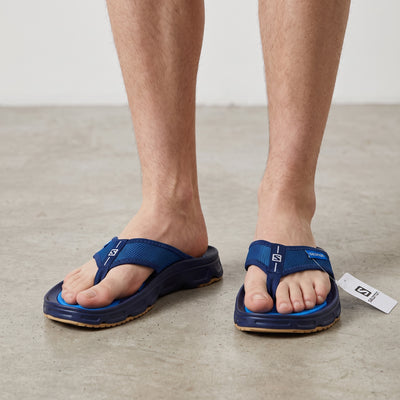 Salomon blue Reelax 6.0 men's thong sandals on model's feet