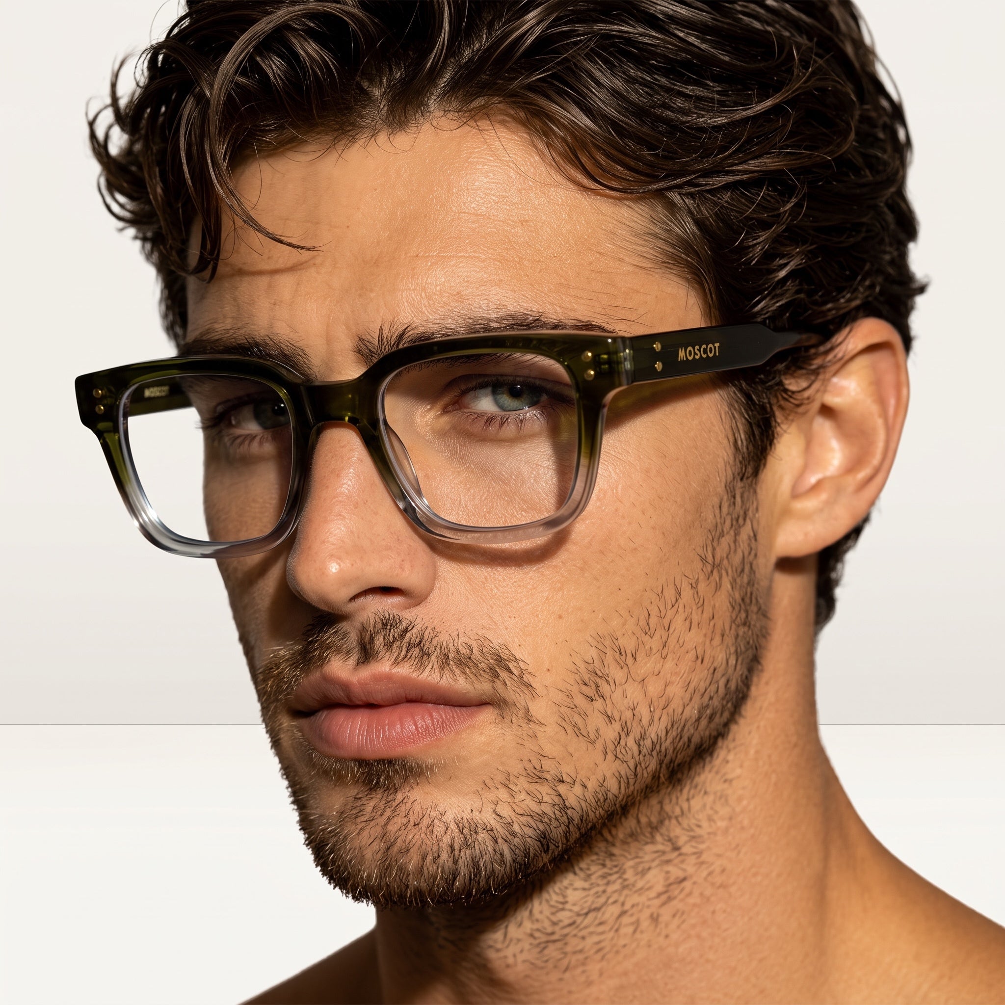 Close-up of Moscot olive-to-clear square frame glasses on male model