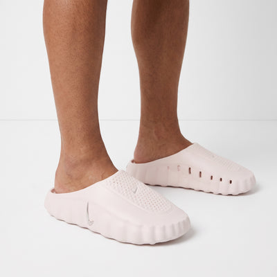 Pale pink Nike slip-on clogs with perforated upper and silver swoosh