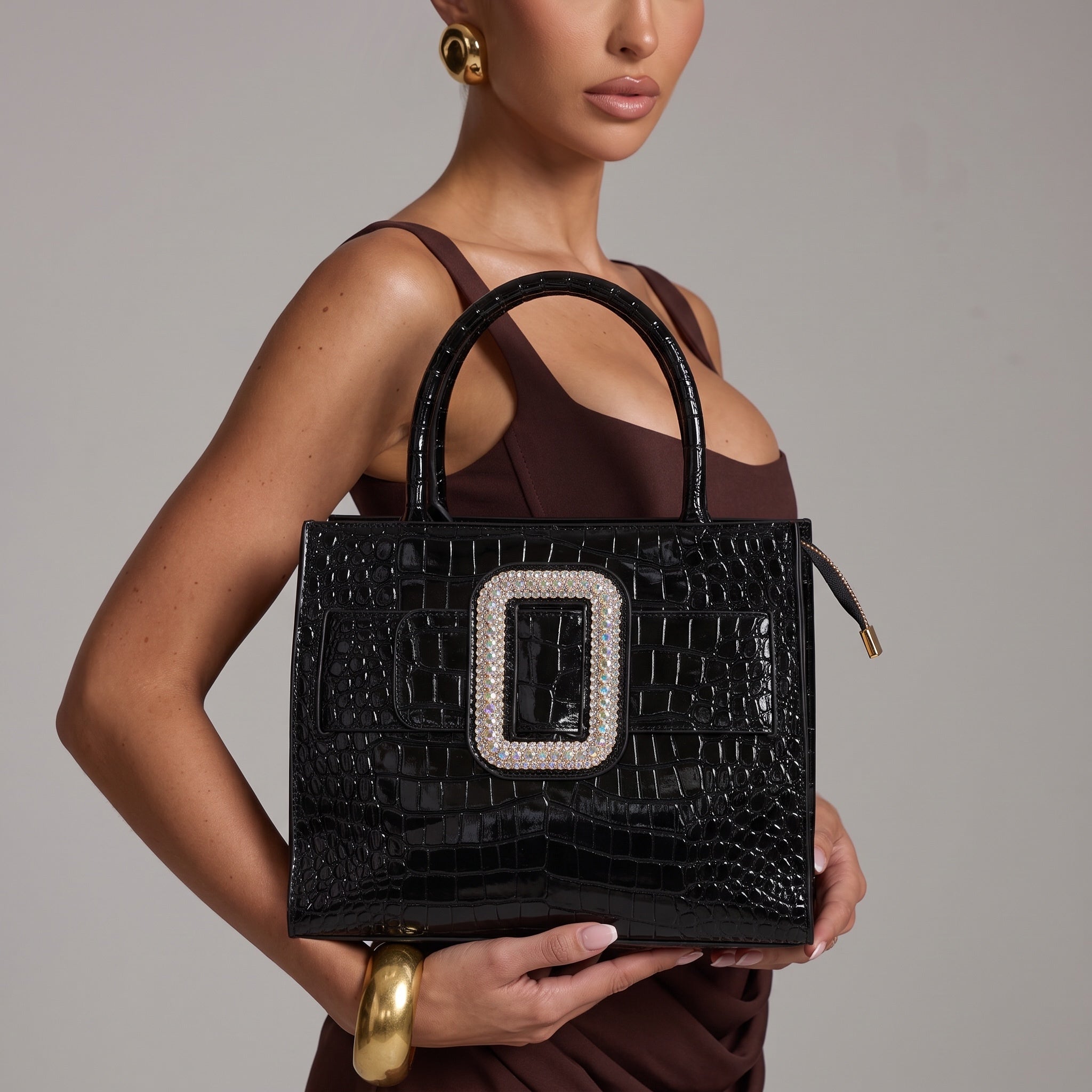 Black croc-effect patent tote bag with large crystal buckle and round top handles
