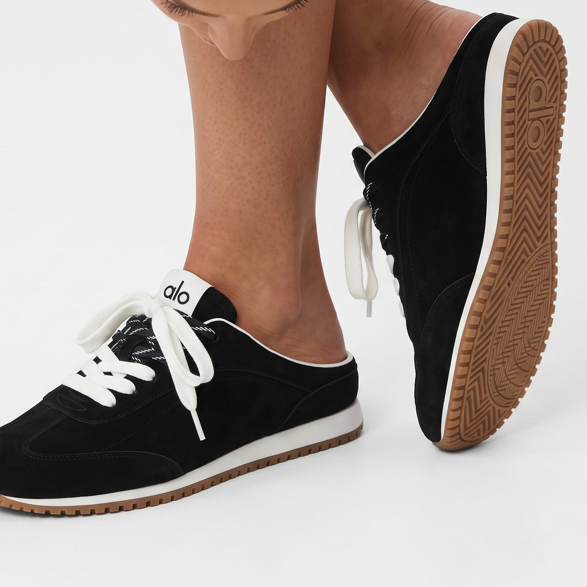 Black low-back Alo sneakers with gum sole and two-tone laces