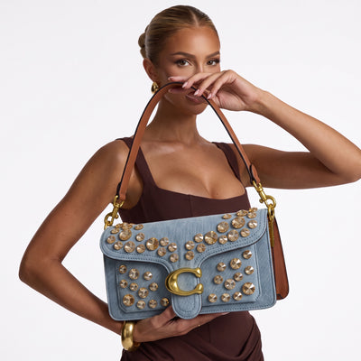 Light blue denim Coach shoulder bag with gold crystal studs and brown leather handle