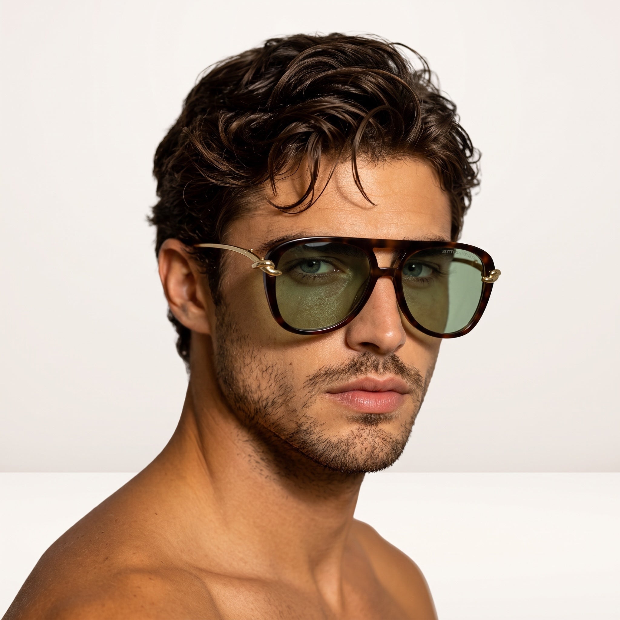 Close-up of man wearing Bottega Veneta tortoiseshell sunglasses with green lenses