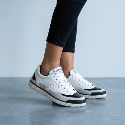 white and black Chanel low-top sneakers with CC logo