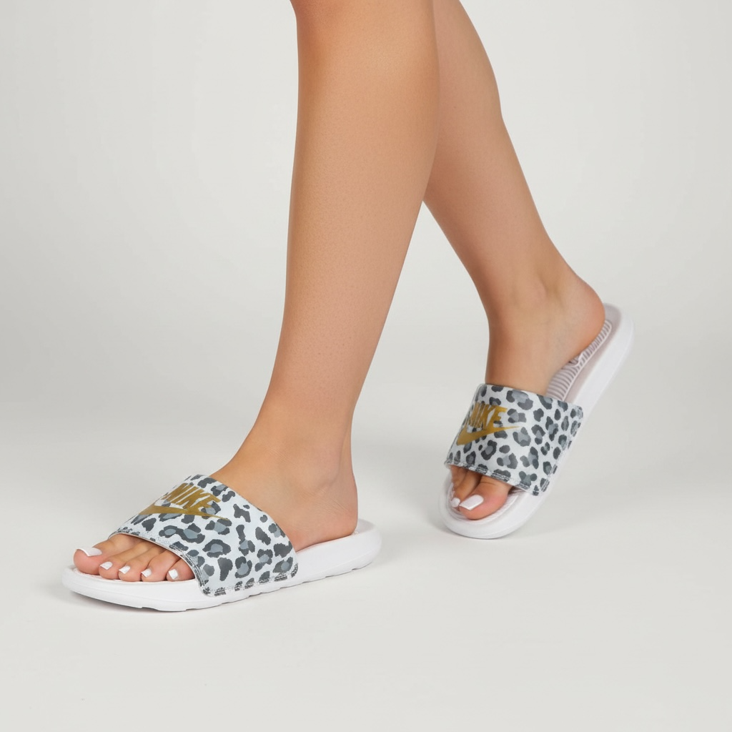 white Nike slide sandals with grey leopard print strap and gold Swoosh