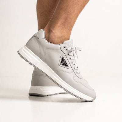 Prada grey low-top sneakers with triangular logo plaque and chunky white sole