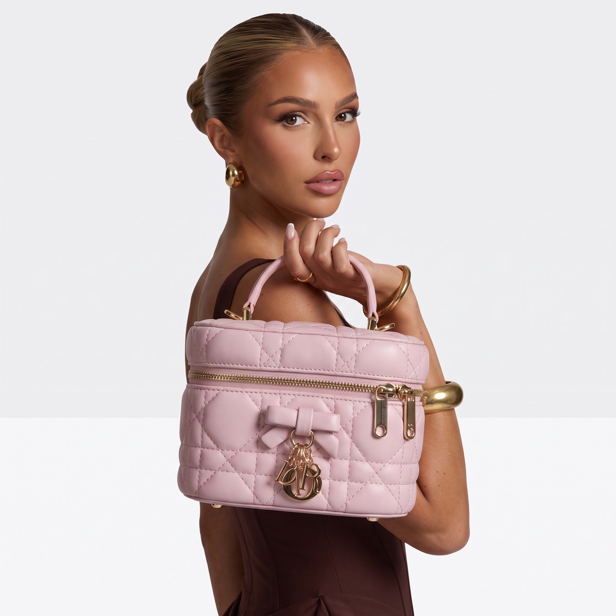pink quilted Dior vanity bag with bow charm and top handle