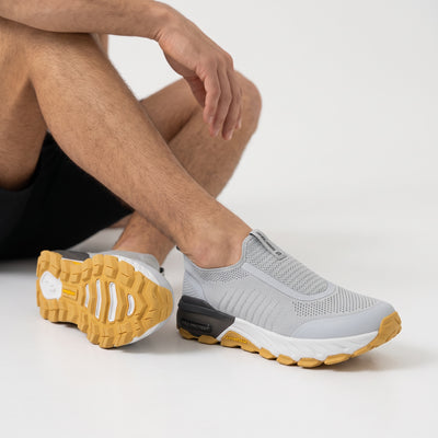 Light grey Skechers slip-on knit sneakers with yellow gum sole