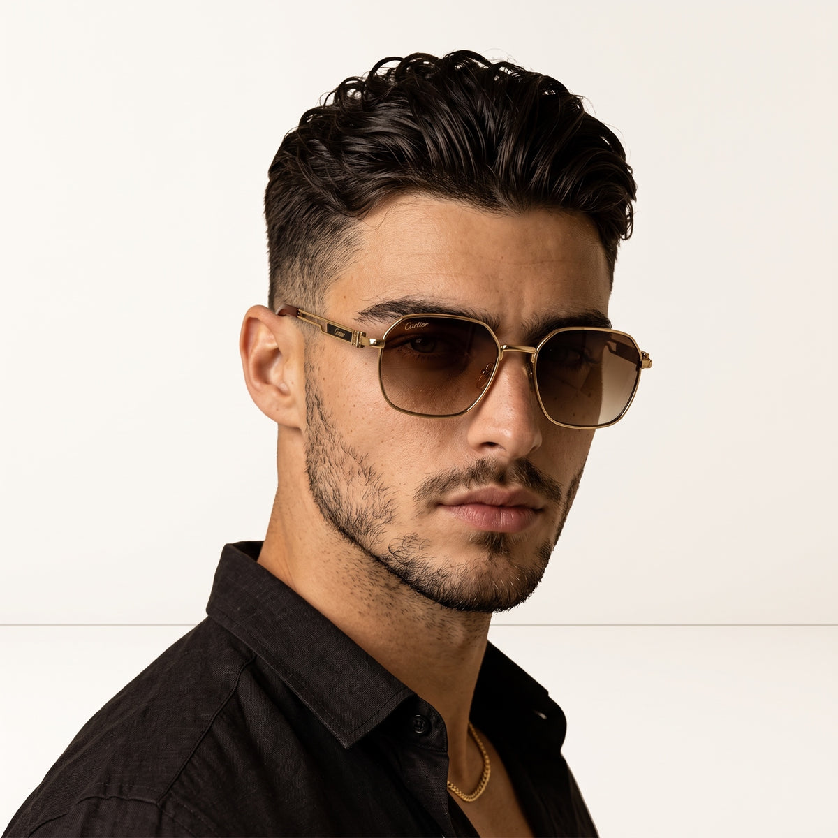 Close-up of man wearing gold Cartier sunglasses with brown gradient lenses