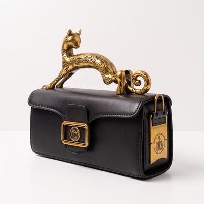 Black mini top-handle bag with sculptural gold cat handle and gold hardware