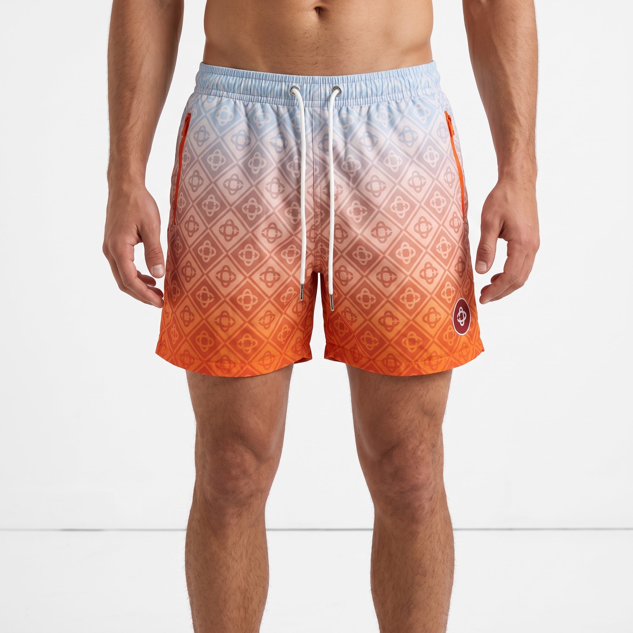 Men's ombre orange to blue monogram swim shorts with drawstring and zip pockets.