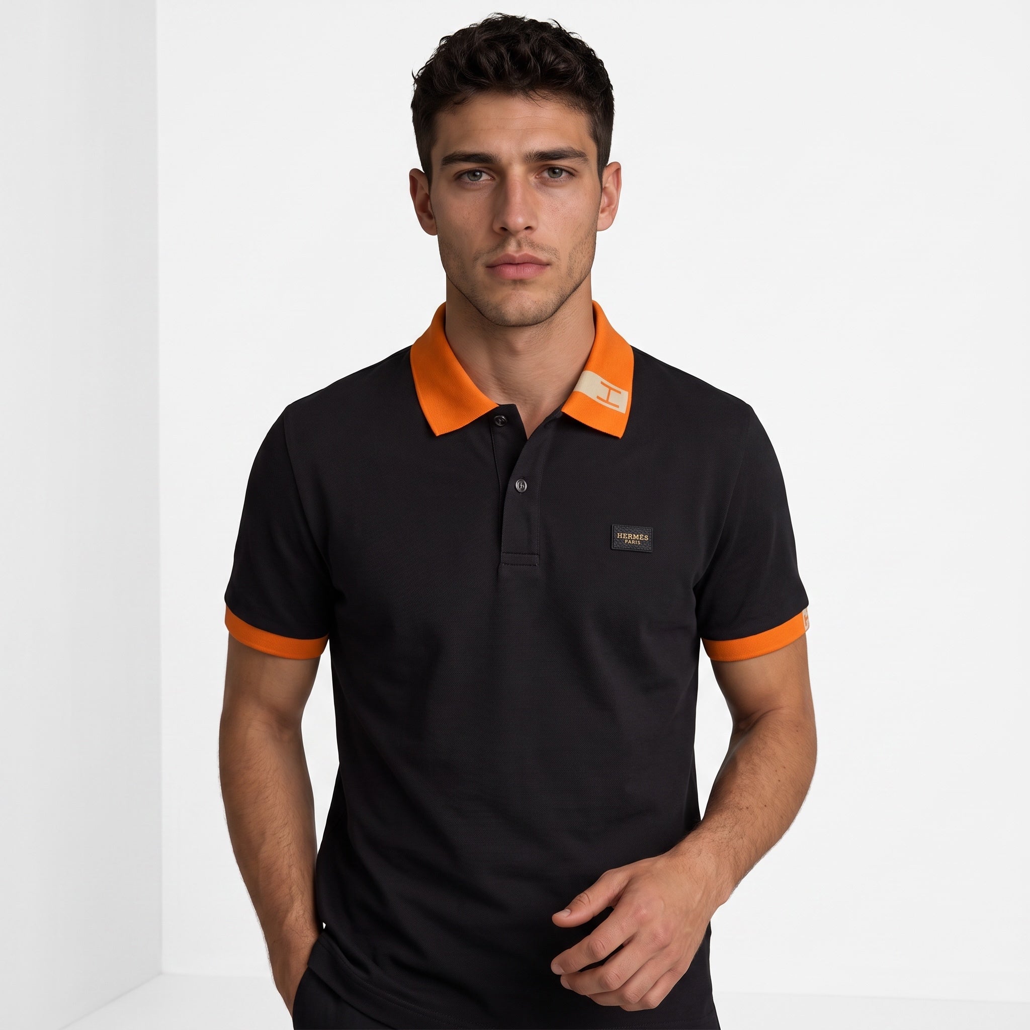 Black Hermès short-sleeve polo with orange collar and cuffs.