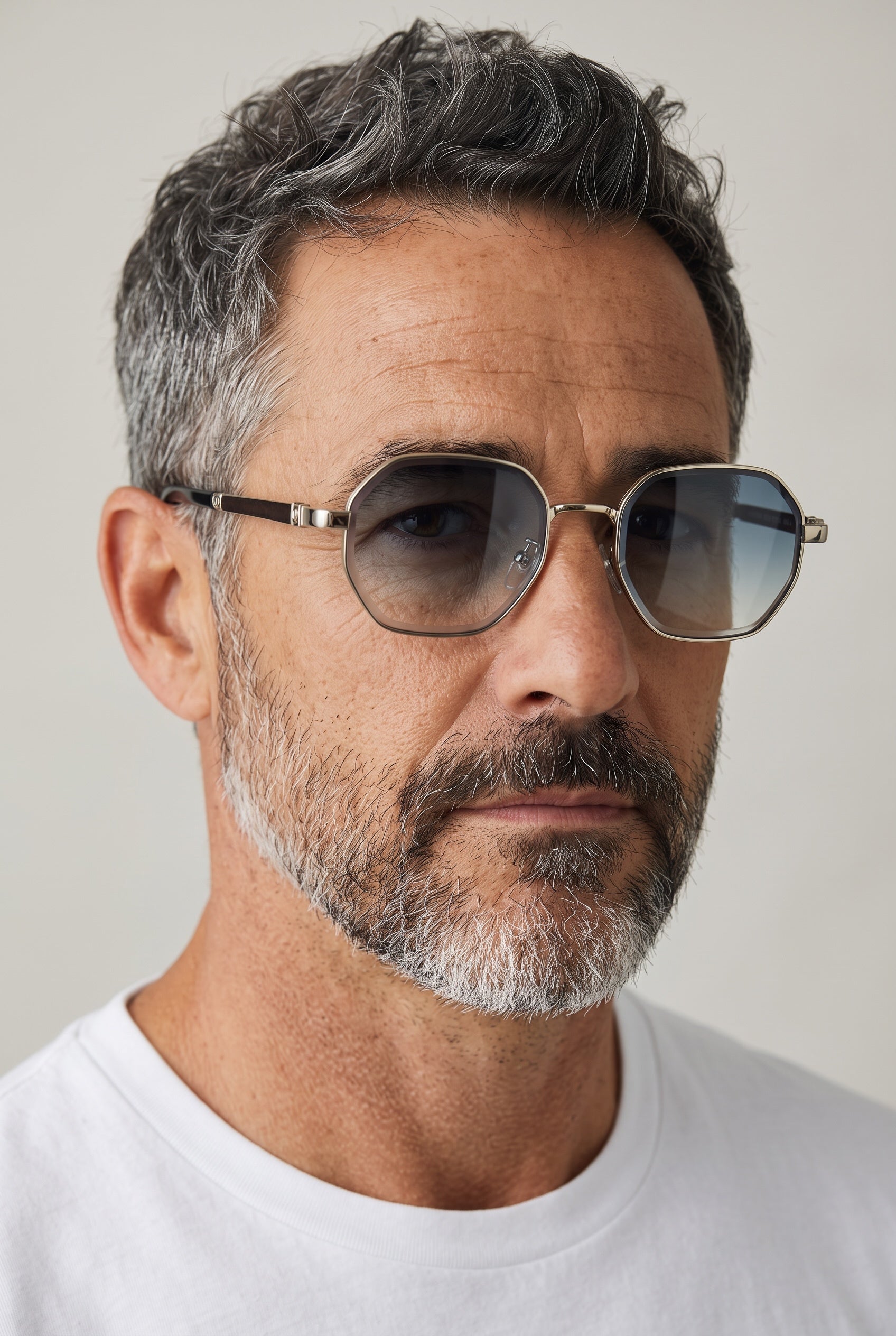 Close-up of man wearing octagon gunmetal sunglasses with gradient lenses