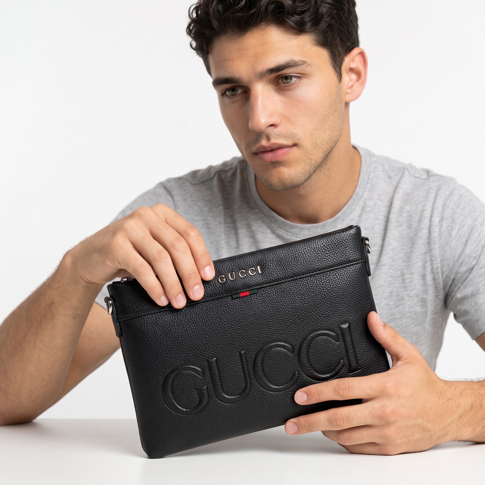 pebbled textured black Gucci messenger bag with embossed logo and red-green stripe
