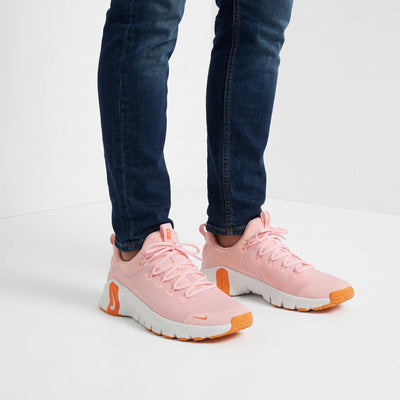 Pink Nike chunky sneakers with orange accents and white sole