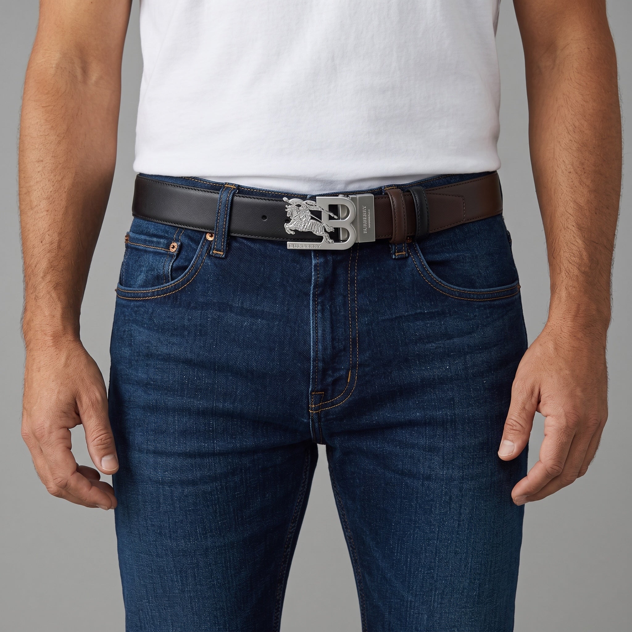 Burberry reversible black and brown leather belt with silver B equestrian buckle worn with jeans