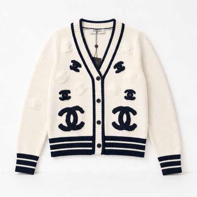 Cream cardigan with navy logo appliqués and navy ribbed trim, button front V-neck