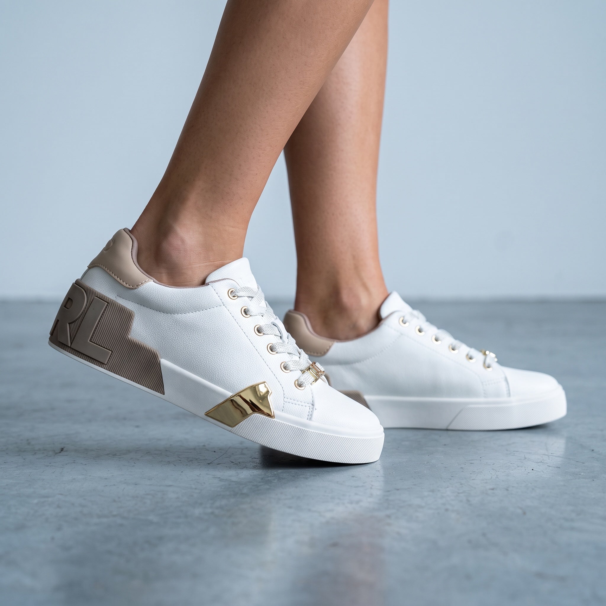 White Karl Lagerfeld low-top sneakers with taupe accents and gold hardware