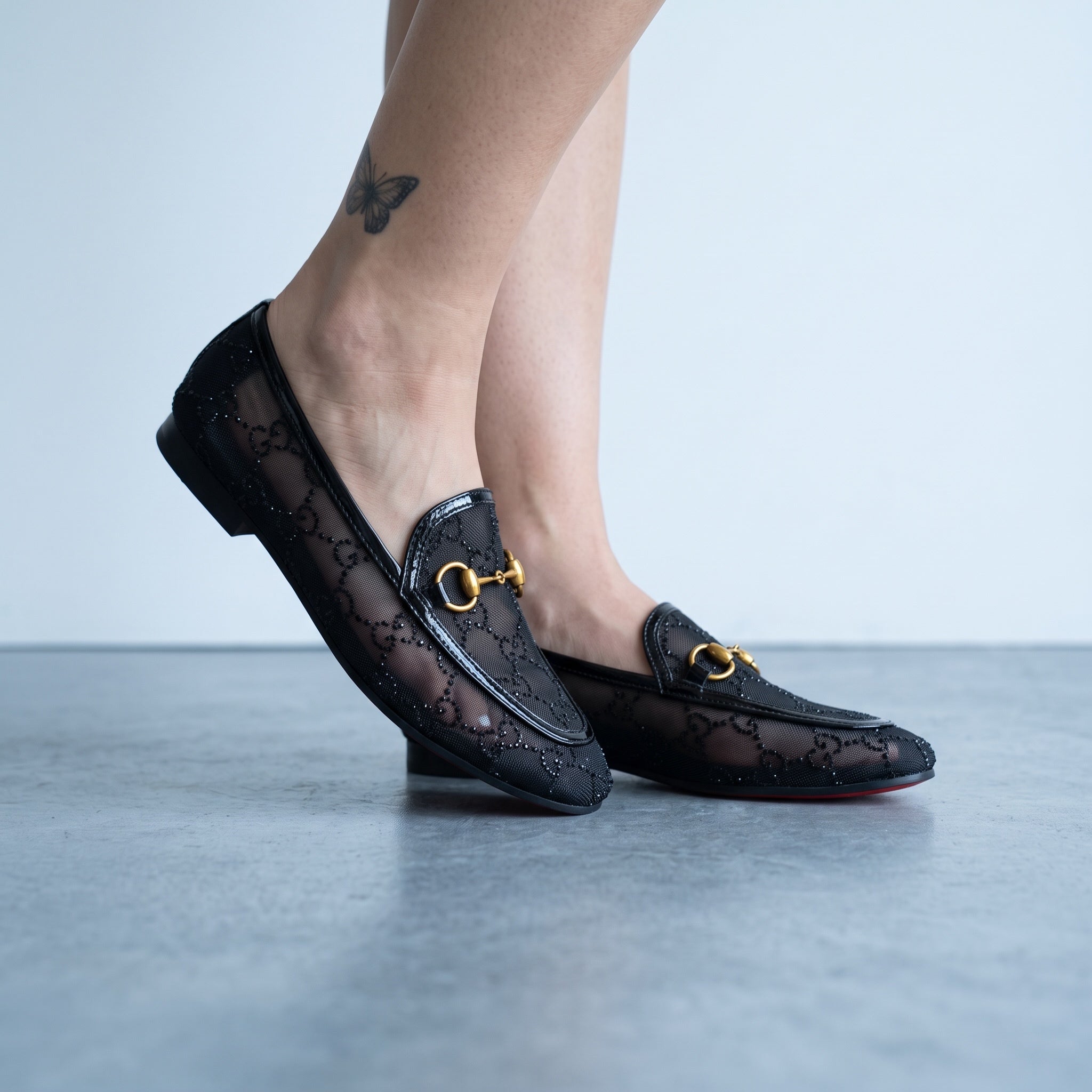 Black Gucci mesh loafers with gold horsebit and red sole