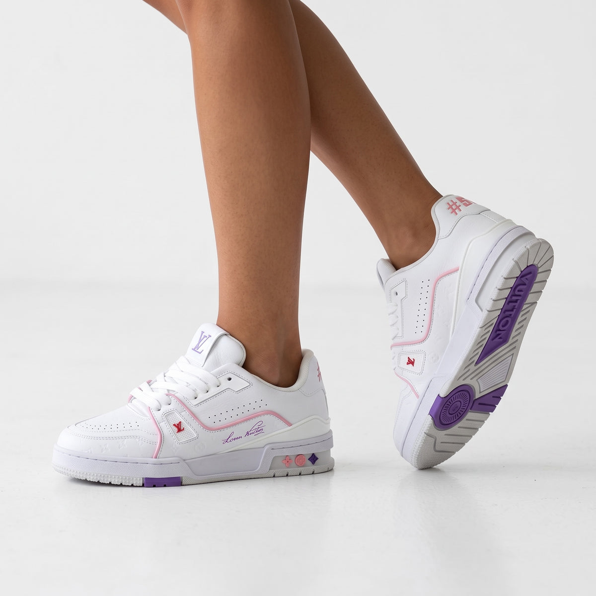 White Louis Vuitton low-top trainer with pink piping, purple sole accents and embossed monogram