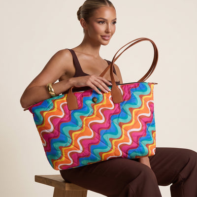 colorful quilted tote bag with brown handles and swirl print