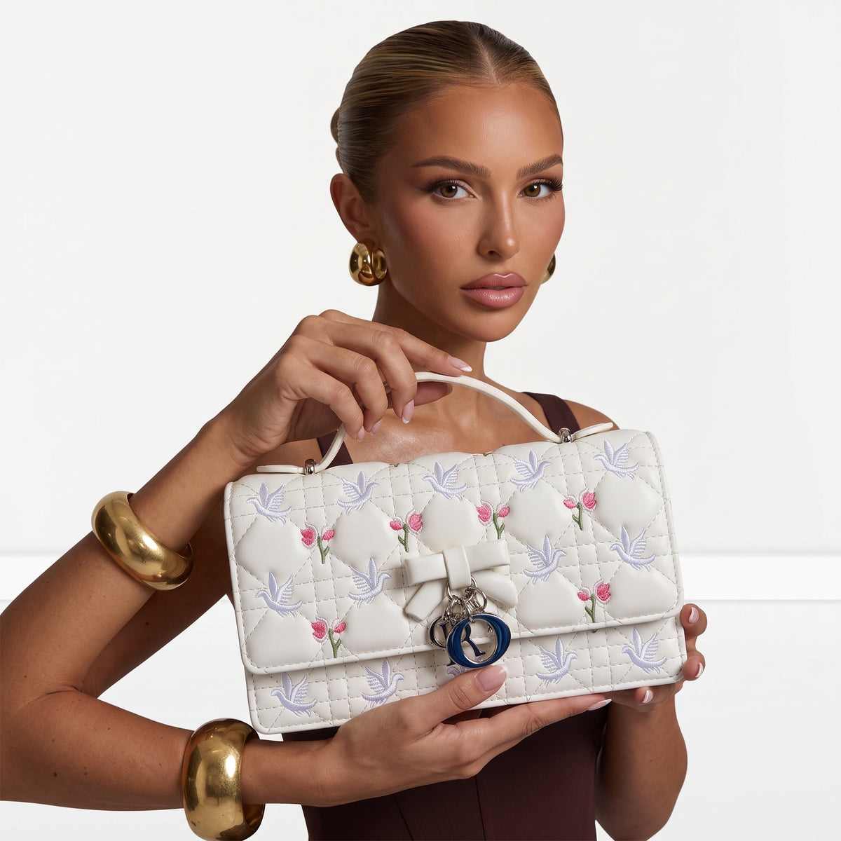 White quilted Dior top-handle bag with embroidered birds and cherries and blue charm letters