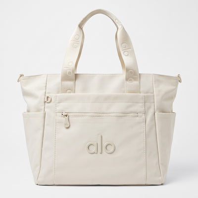 Cream Alo Yoga tote with branded webbing handles and front zip pocket