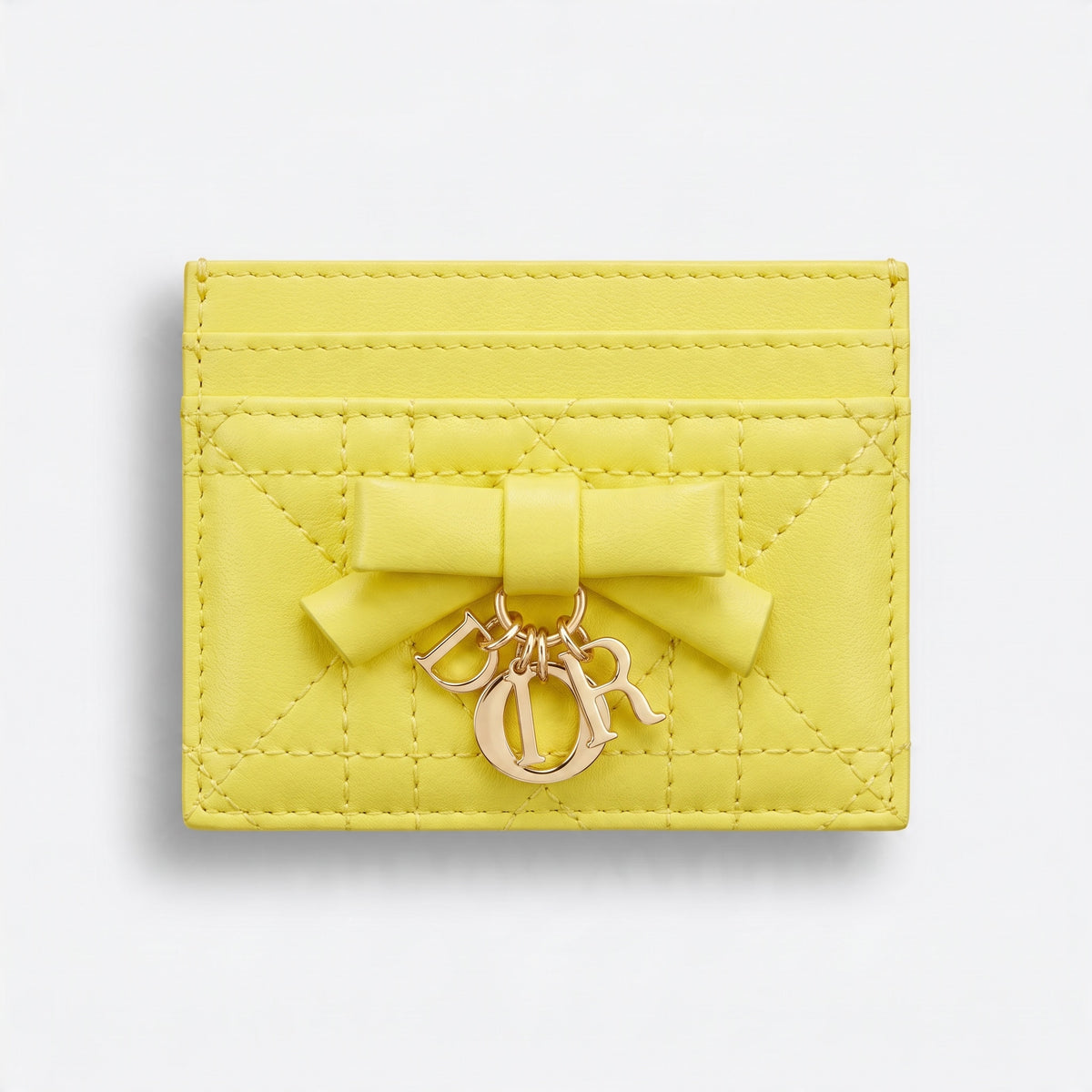 yellow quilted Dior card holder with bow and gold letter charms