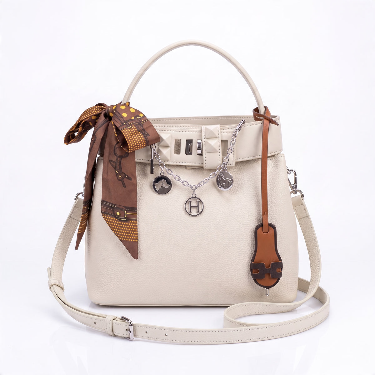 Cream Hermès top-handle tote with charm chain and tied brown silk scarf