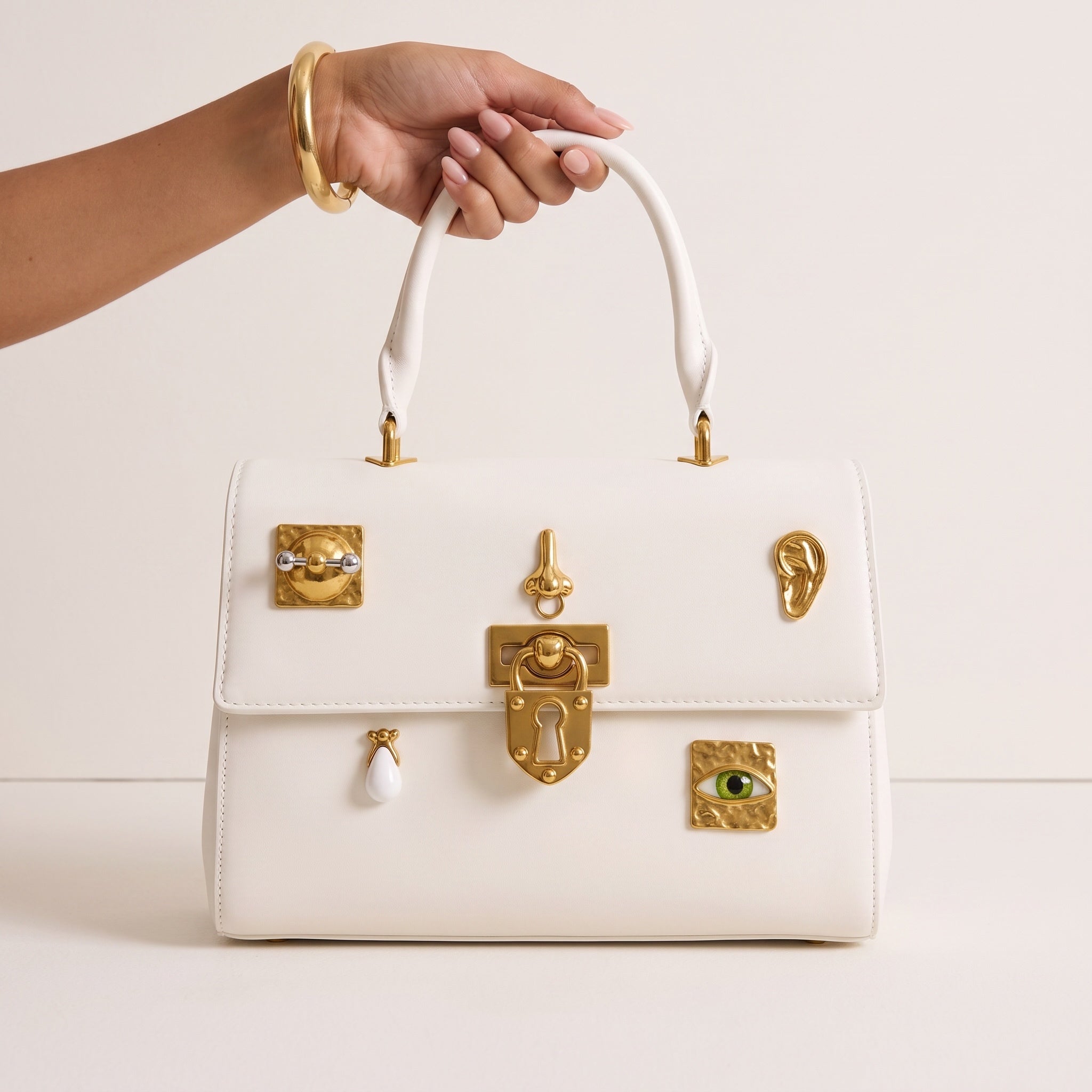 White top-handle bag with gold hardware and decorative charms