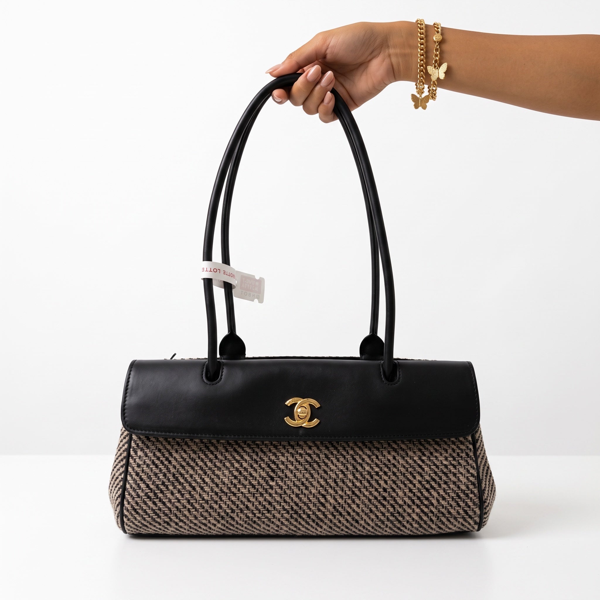 Chanel top-handle bag with black leather flap, gold CC hardware and beige patterned body