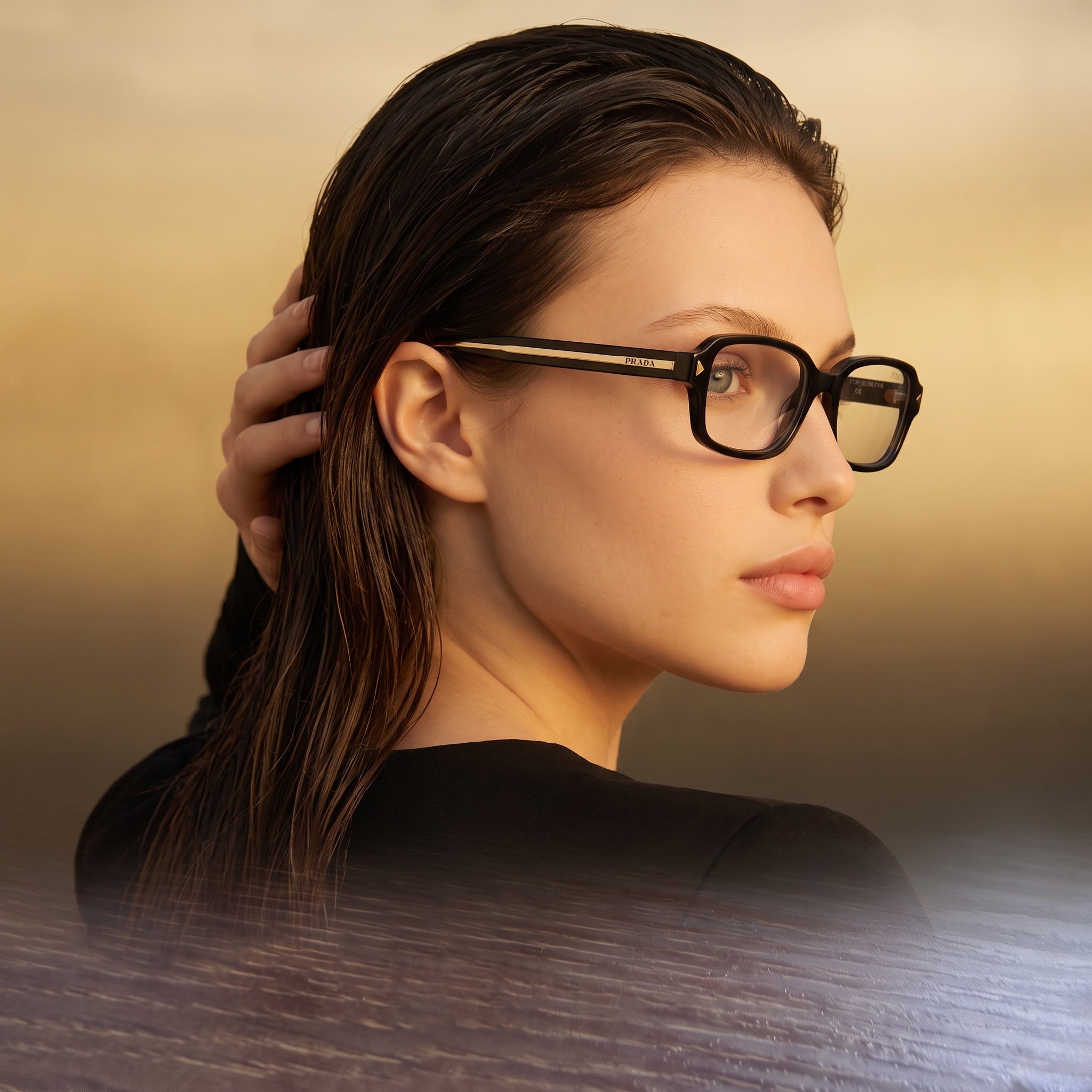 Prada black rectangular eyeglasses with gold trim on temple