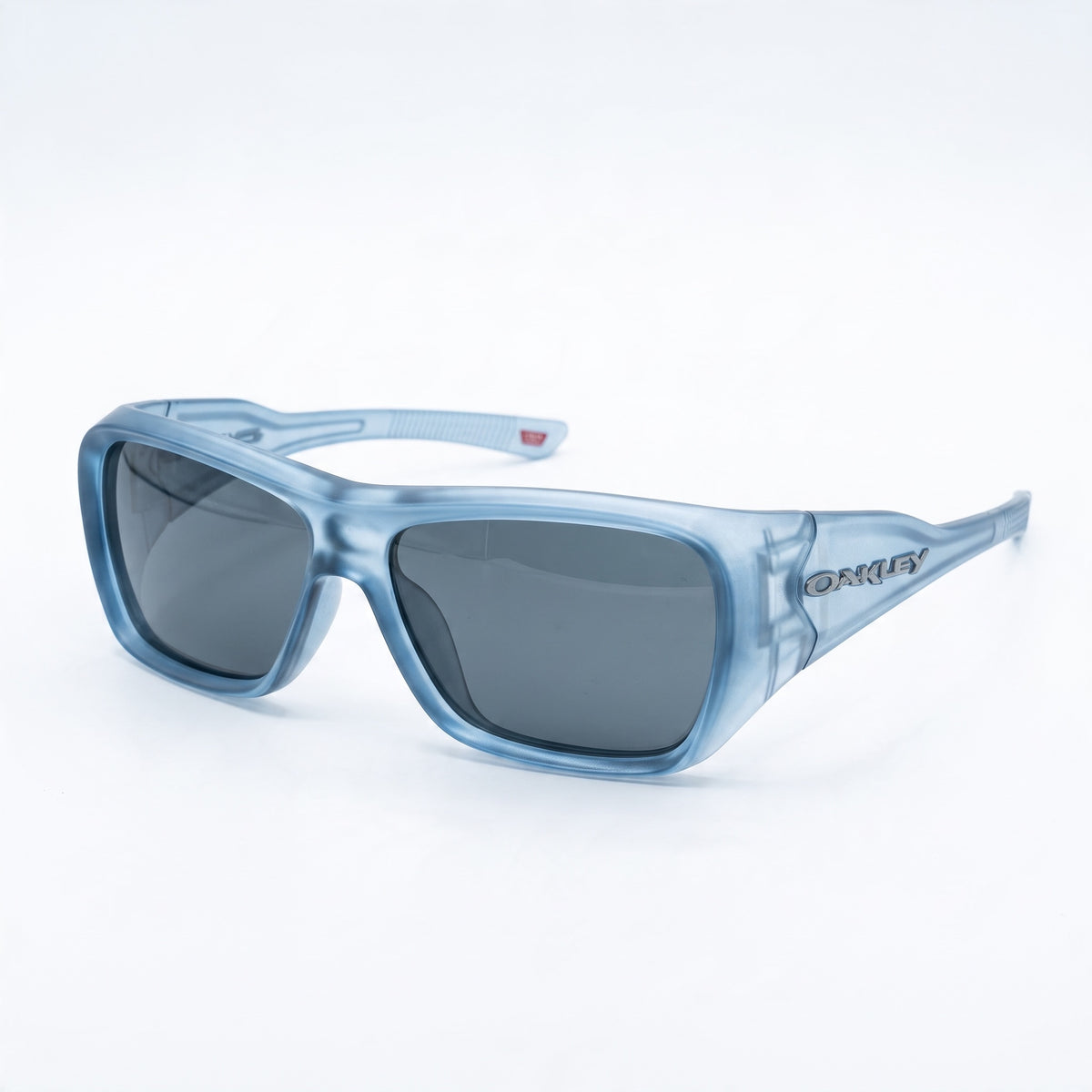 Translucent blue Oakley sunglasses with grey lenses, close-up.