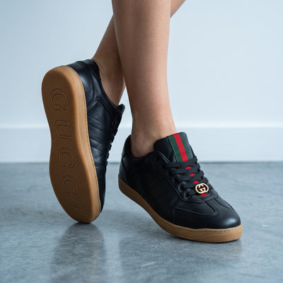 black Gucci Ace sneakers with green red web and gold GG on gum sole