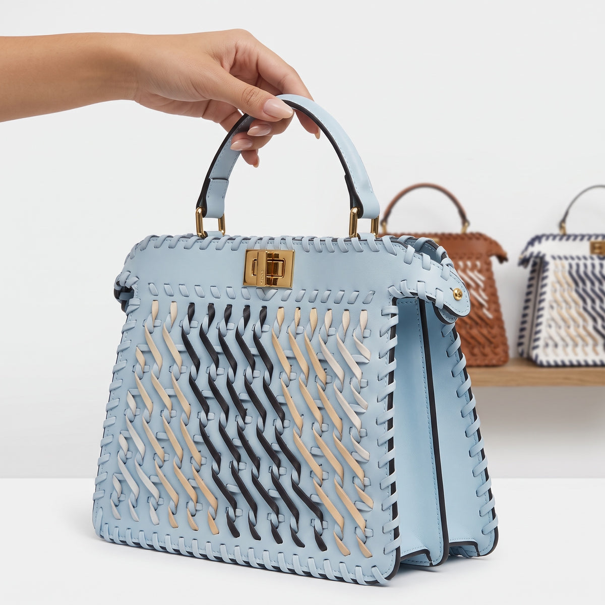Sky blue woven top-handle bag with gold turn-lock and woven strip detail