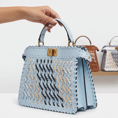 Sky blue woven top-handle bag with gold turn-lock and woven strip detail