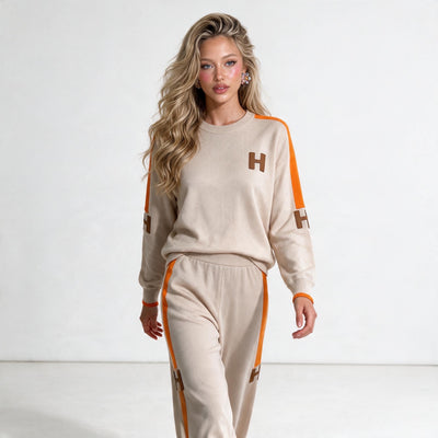 Beige knit two-piece tracksuit with orange side stripes and H logo patches