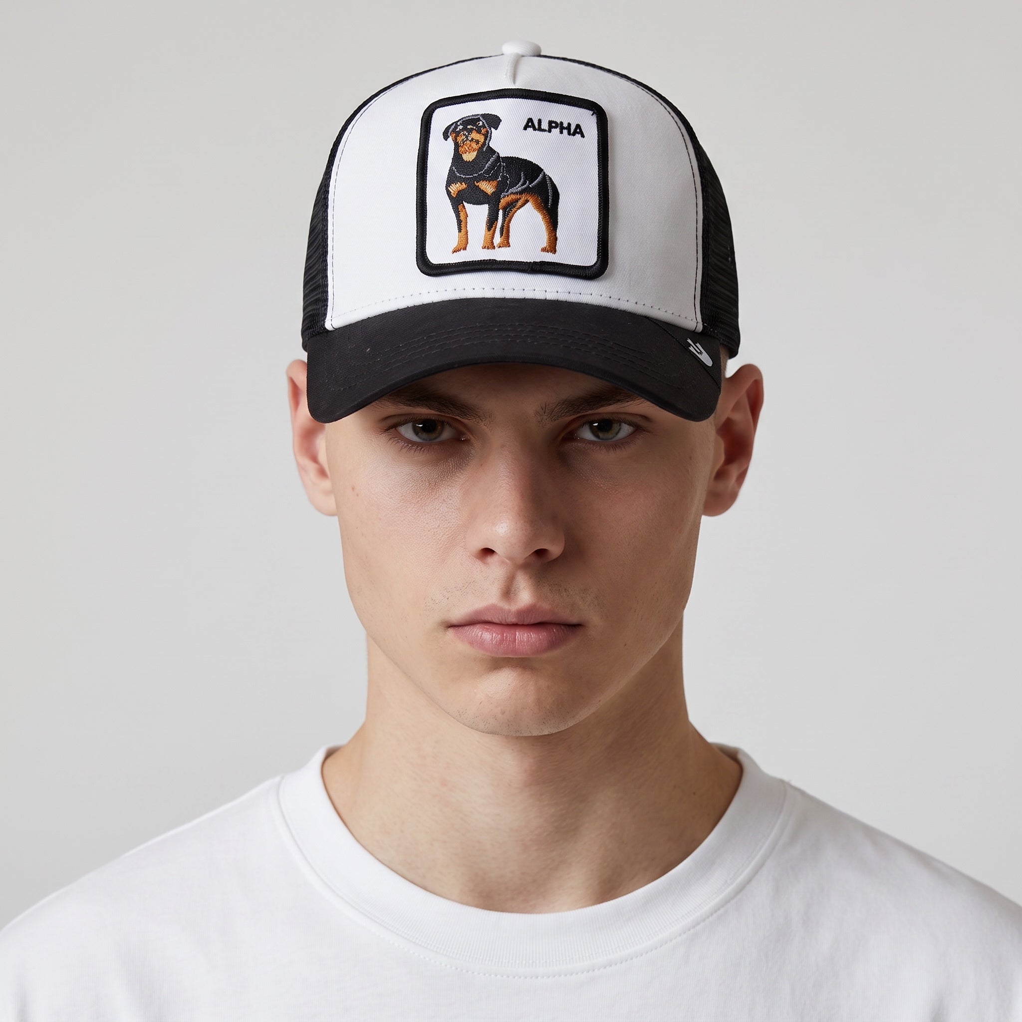 Black and white trucker cap with embroidered Rottweiler patch and ALPHA text