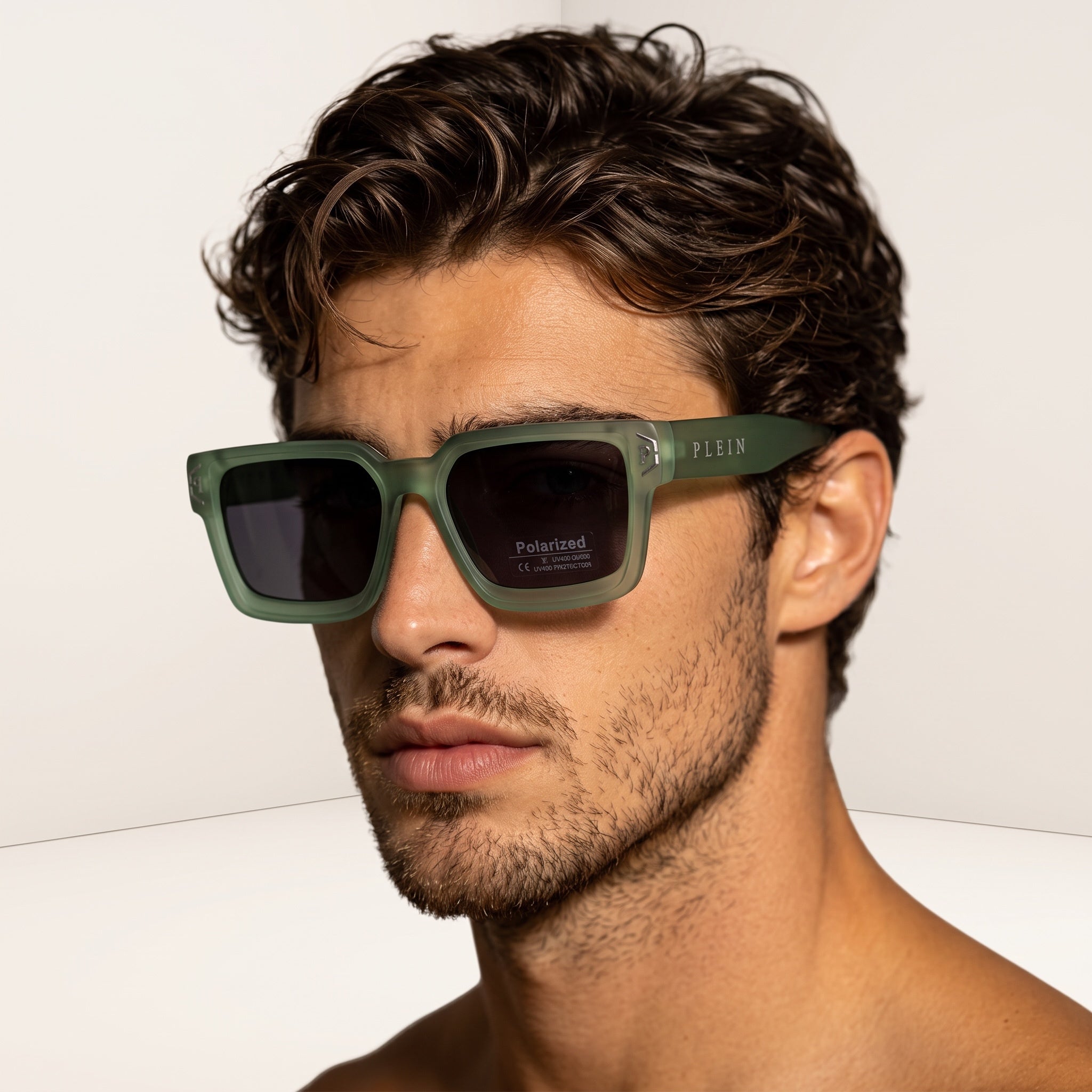 Model wearing matte green rectangular Philipp Plein sunglasses with polarized dark lenses